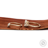 Side profile view of pear ring and curved band set
