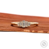 Front view of dainty five stone baguette moissanite ring in yellow gold.