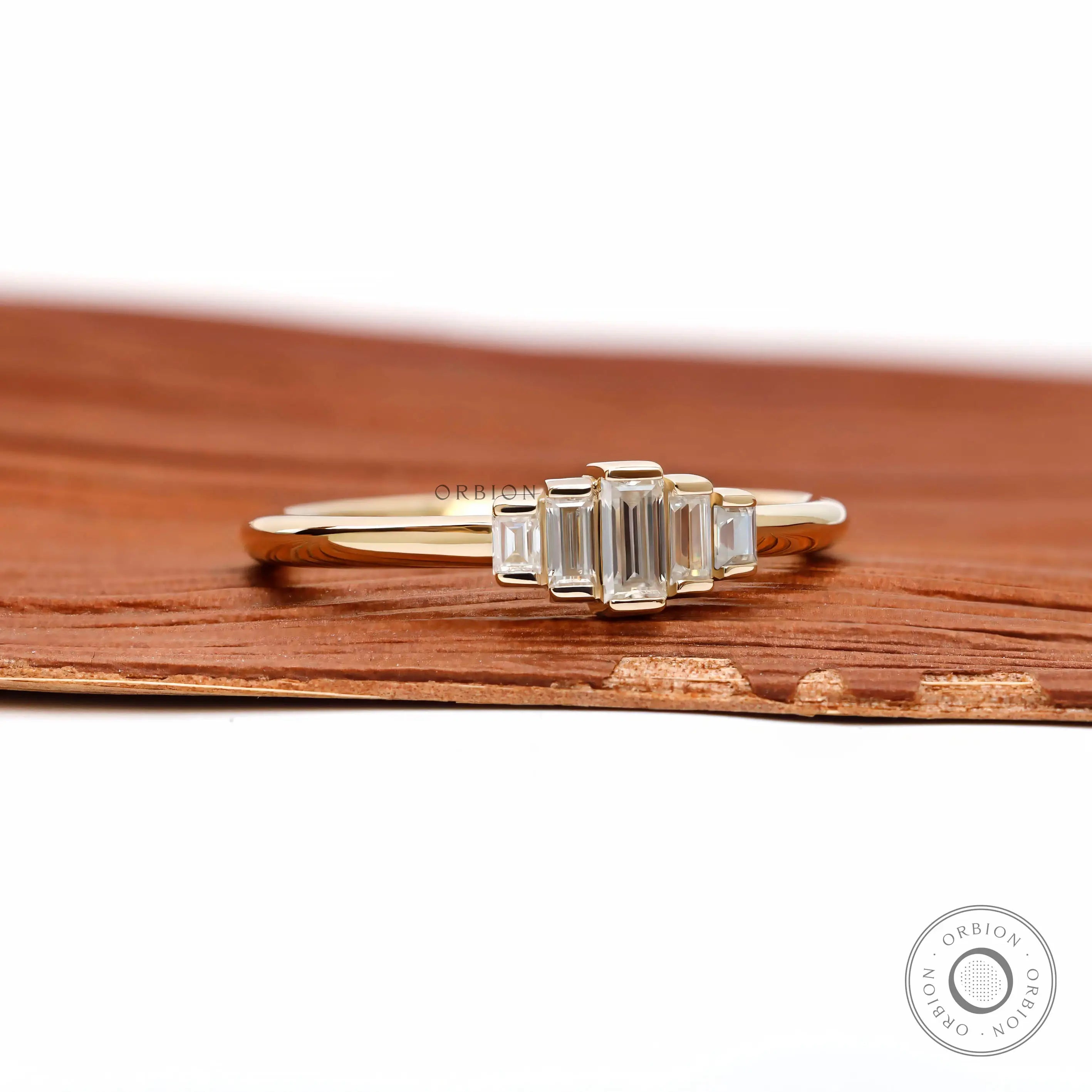 Angled front view showing tapered baguette arrangement in yellow gold.