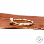 Side profile showing slim yellow gold band and low setting.