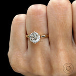 Front close view of round solitaire diamond ring on finger.
