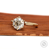 Angled front view of round diamond solitaire yellow gold ring.