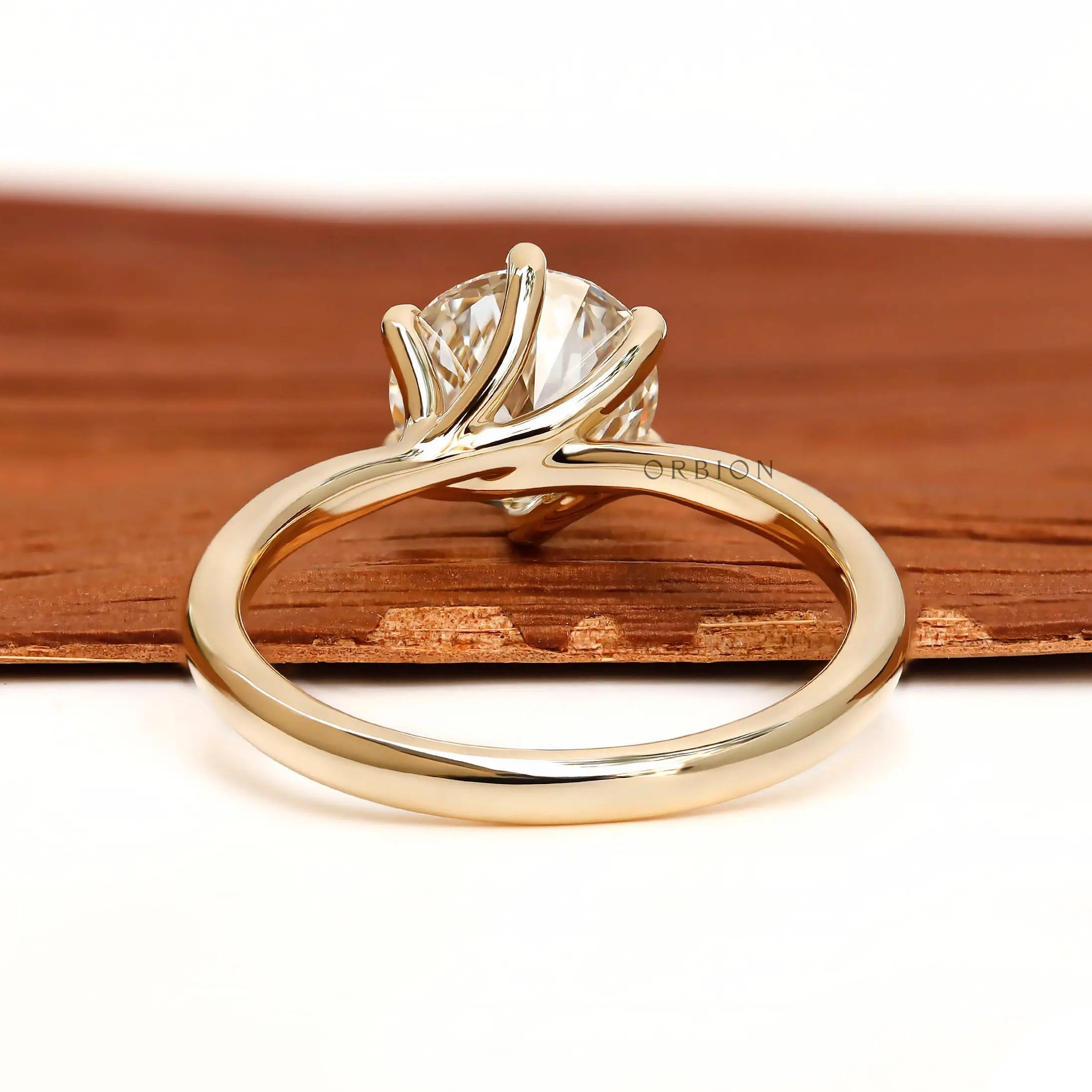 Back view of twisted solitaire ring with polished gold band.