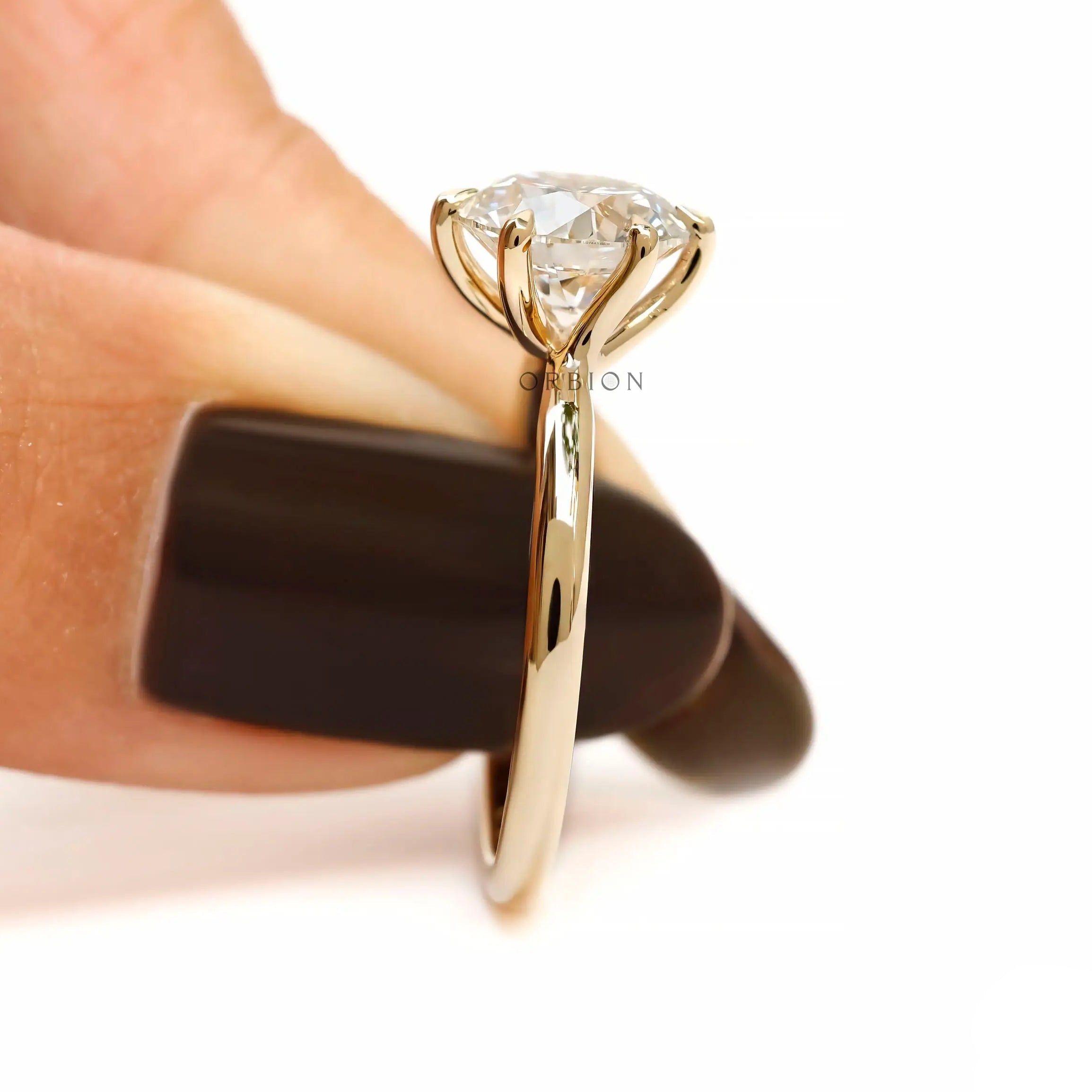 Side held view of round solitaire ring with raised setting.
