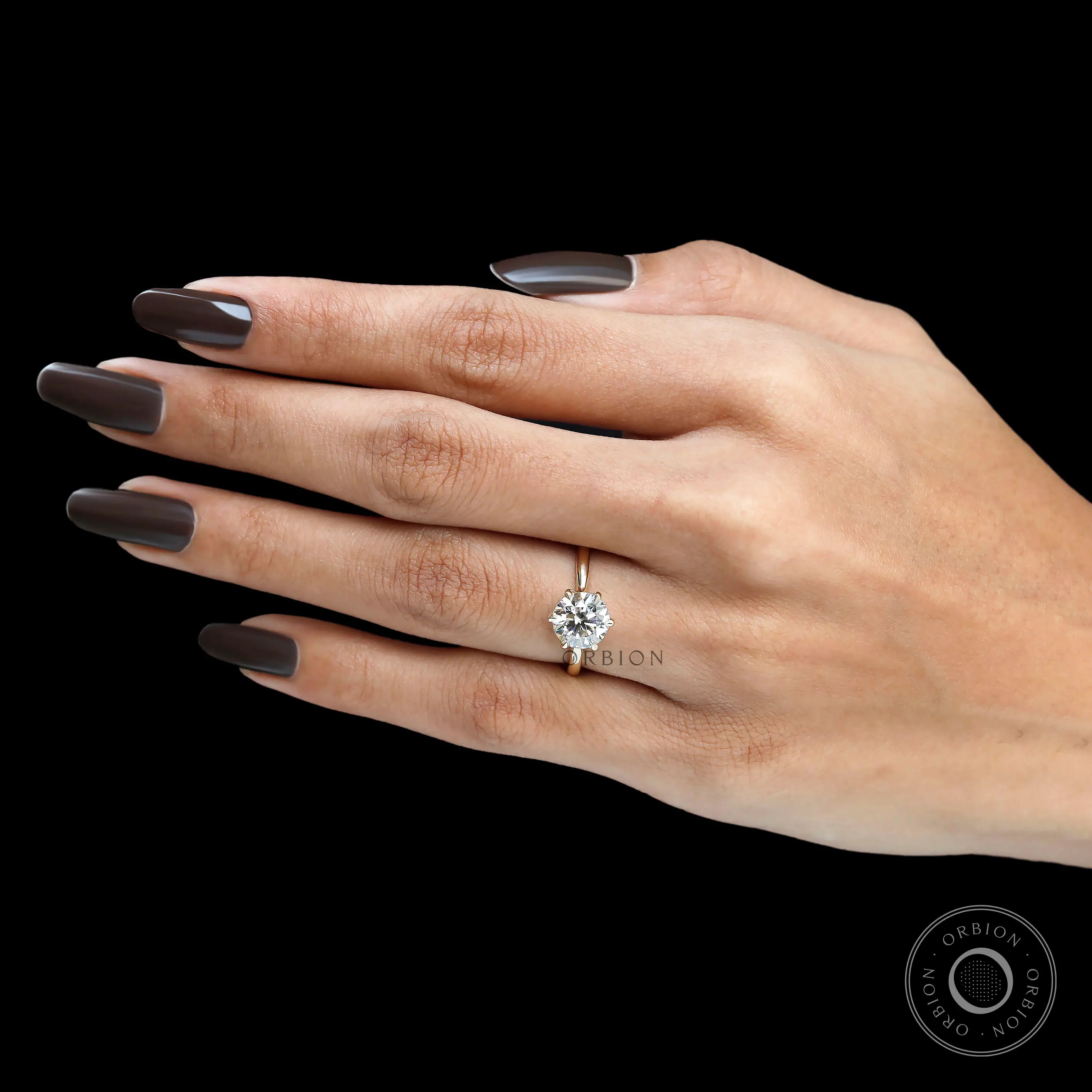 Hand view of round solitaire lab diamond ring in gold.