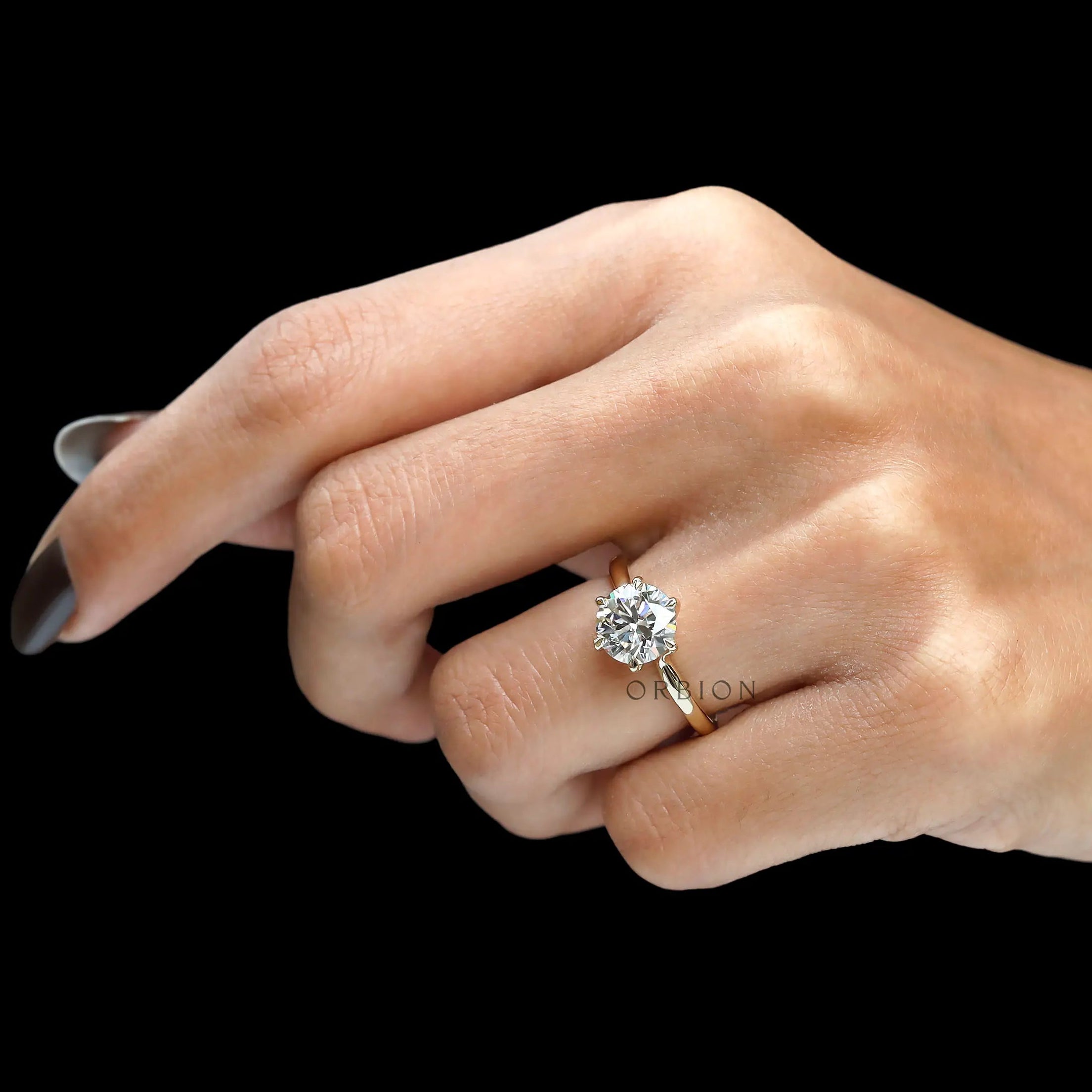 Angled worn view of classic round diamond solitaire ring.