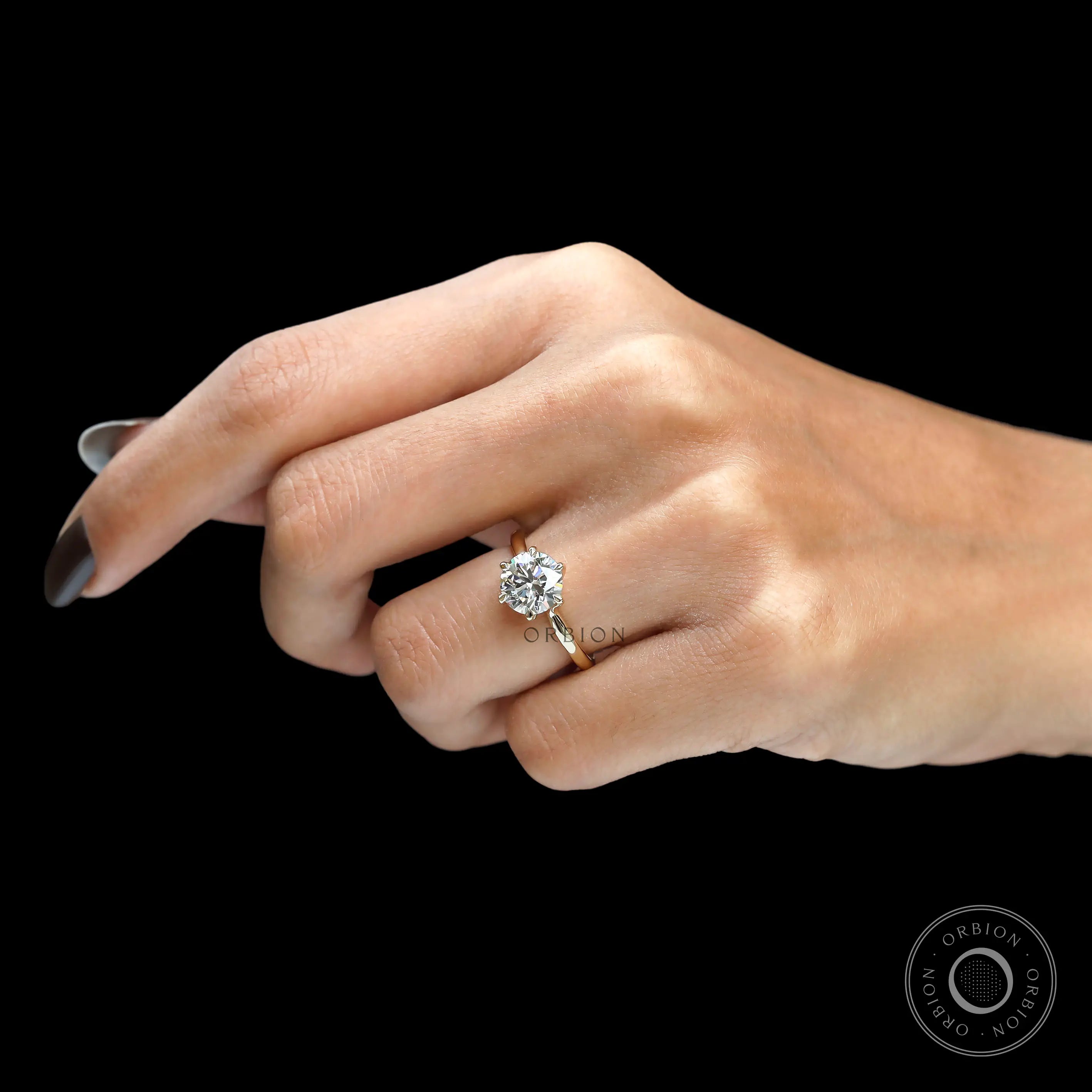 Angled worn view of classic round diamond solitaire ring.