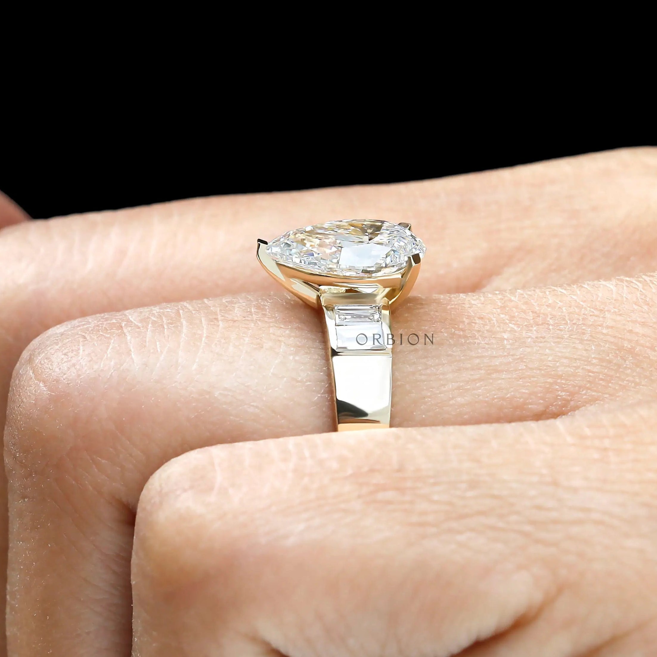 Top hand view pear lab diamond ring with baguette sides