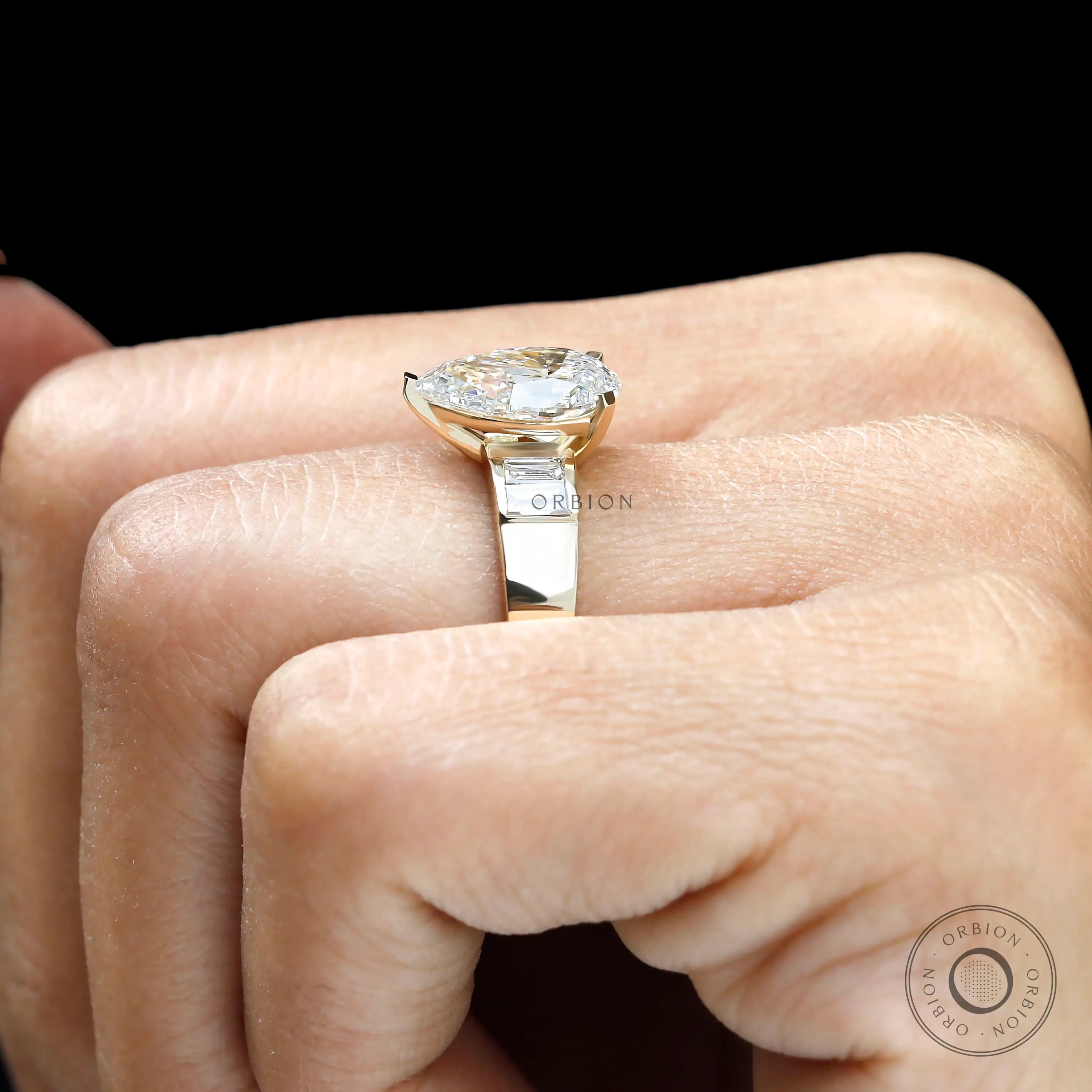 Top hand view pear lab diamond ring with baguette sides