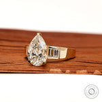Angled front view pear diamond ring with baguette accents
