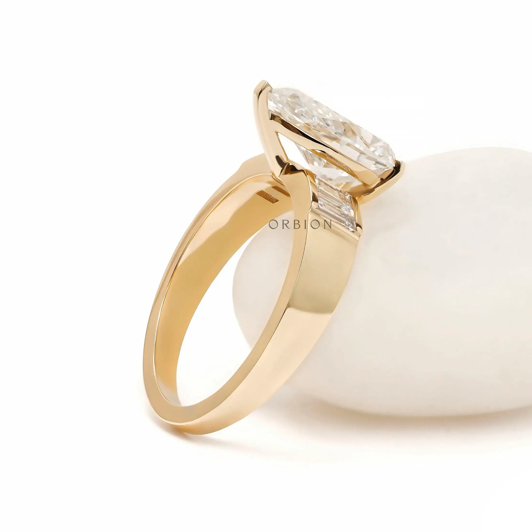 Rear angled view pear diamond ring on white display stone