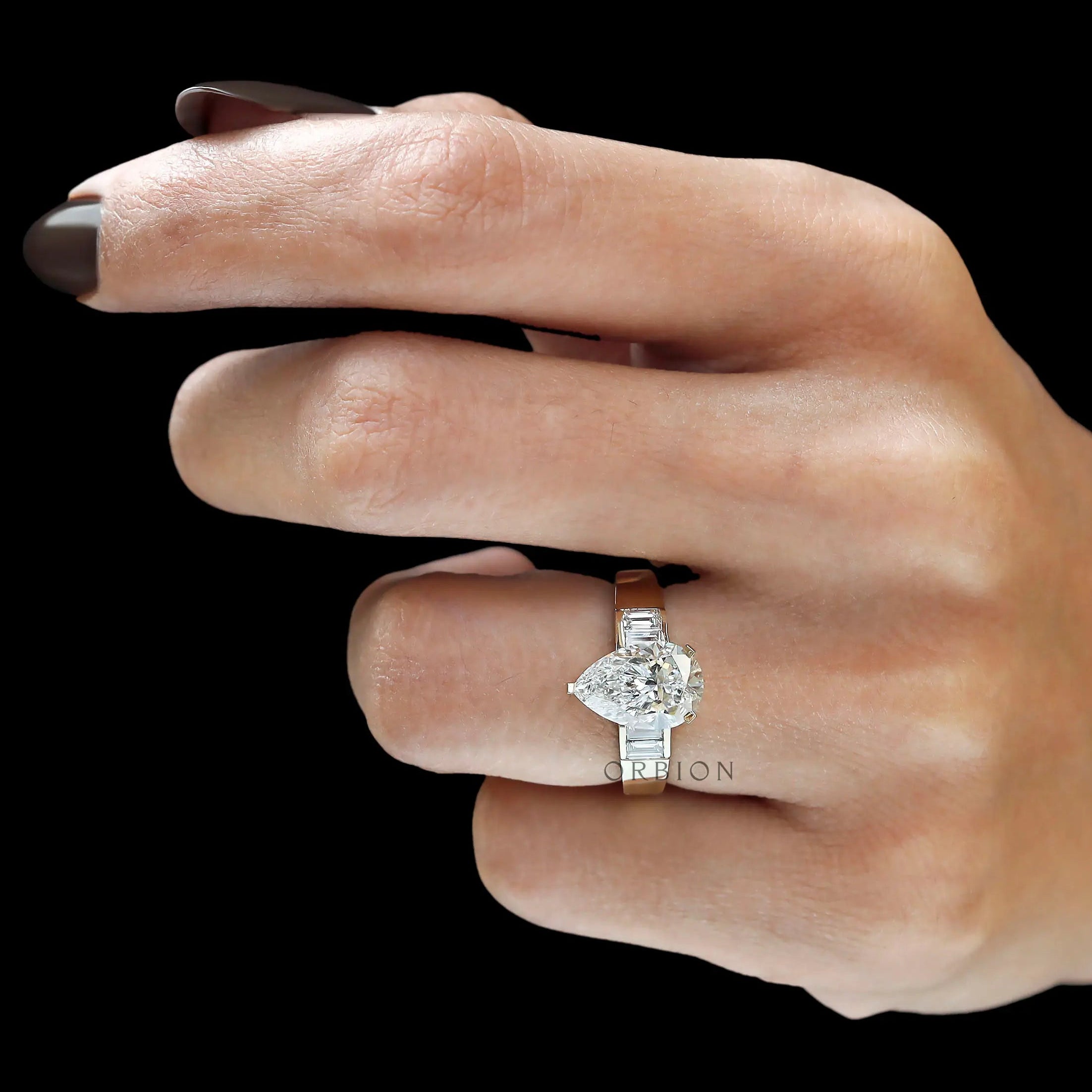 Lifestyle hand shot pear diamond ring with baguette sides