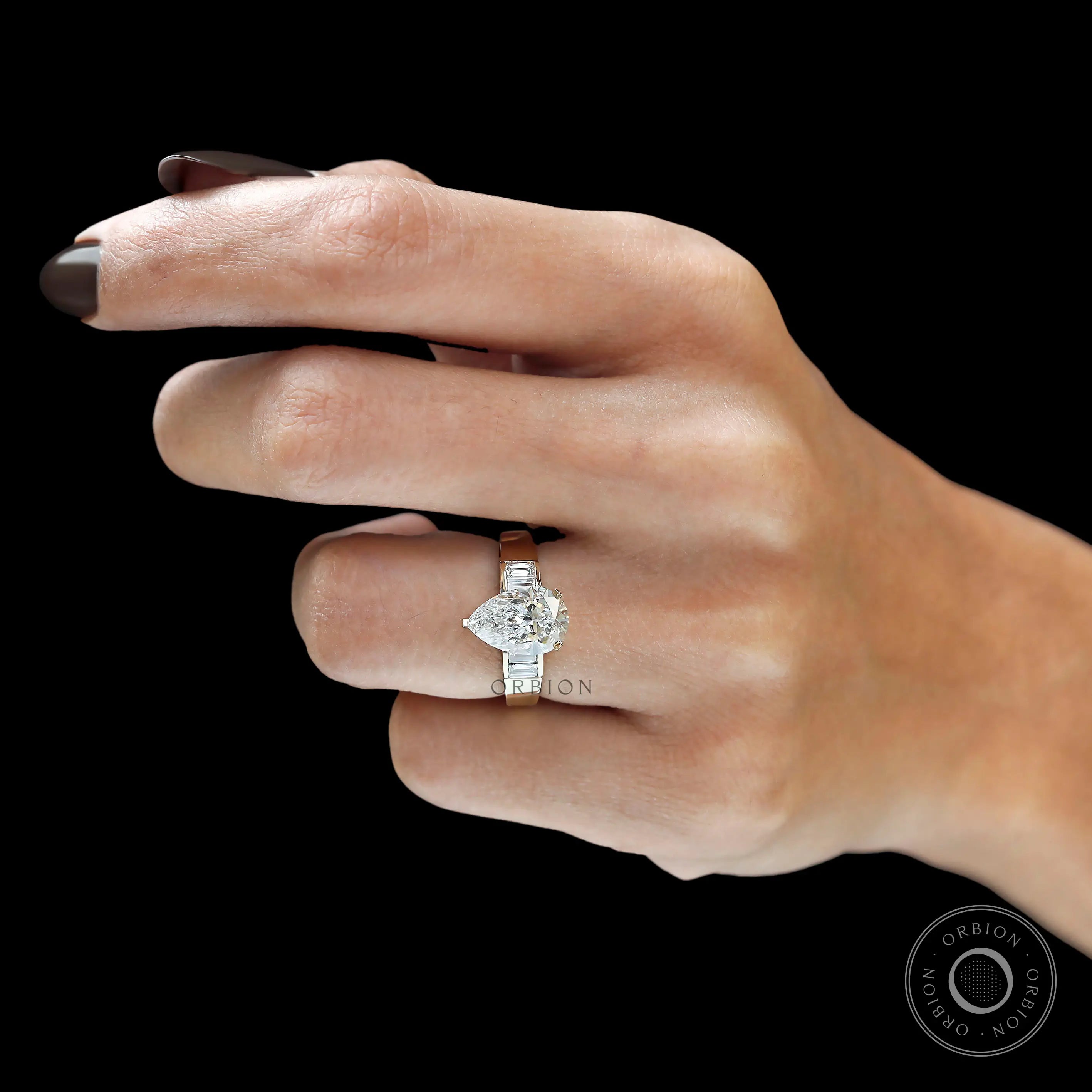 Lifestyle hand shot pear diamond ring with baguette sides