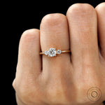Minimalist three stone engagement ring on finger yellow gold