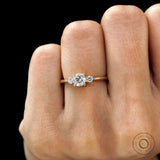 Minimalist three stone engagement ring on finger yellow gold