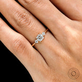 Close up of prong set round cut 3 stone ring yellow gold 
