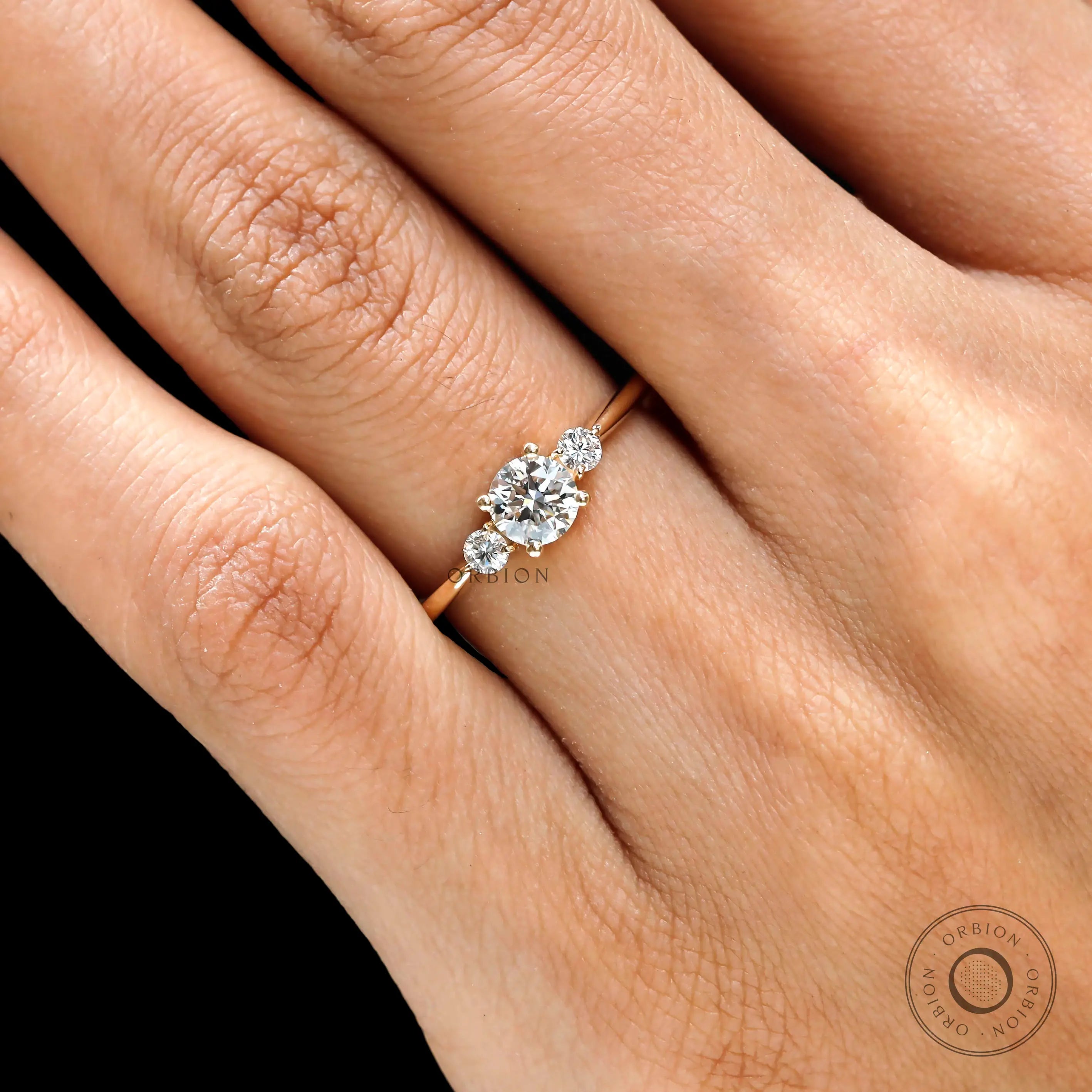 Close up of prong set round cut 3 stone ring yellow gold 