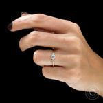Dainty three stone engagement ring on hand yellow gold