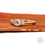 Side profile of round three stone lab  diamond ring yellow gold