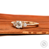 Side profile of round three stone lab  diamond ring yellow gold