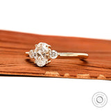 Side profile of dainty oval three stone ring in yellow gold