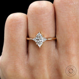 Minimal three stone ring with marquise center diamond