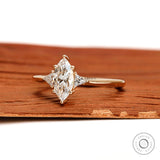 Marquise moissanite engagement ring with triangle side stones