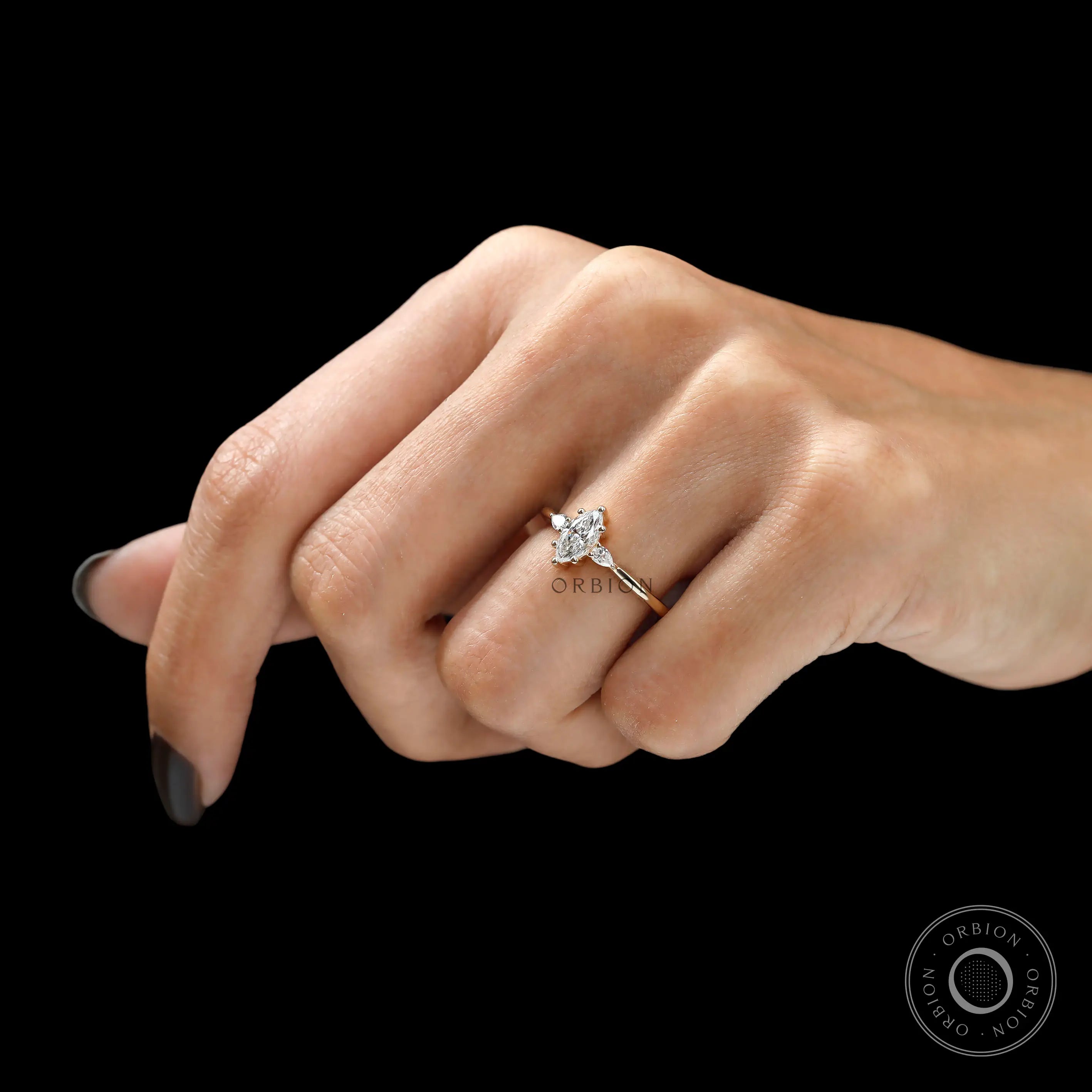 Hand worn view of three stone marquise diamond engagement ring