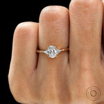 Minimalist oval diamond ring with triangle side stones close up