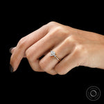 Minimal three stone engagement ring in yellow gold on finger