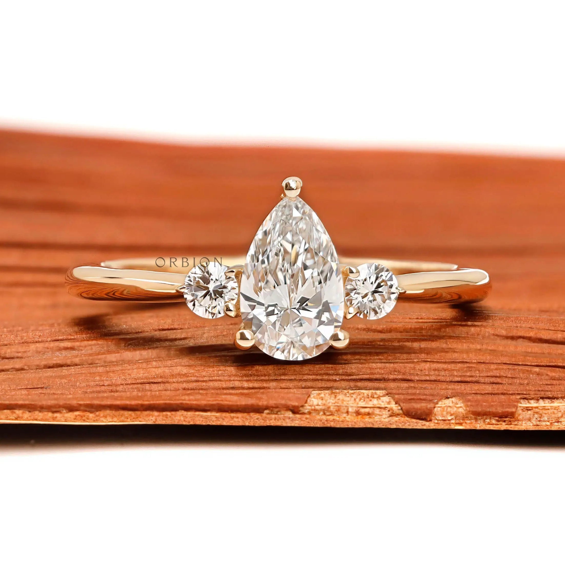 Pear and round three stone lab diamond ring in 10k yellow gold front view