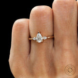 Minimal 3 stone pear engagement ring yellow gold close up