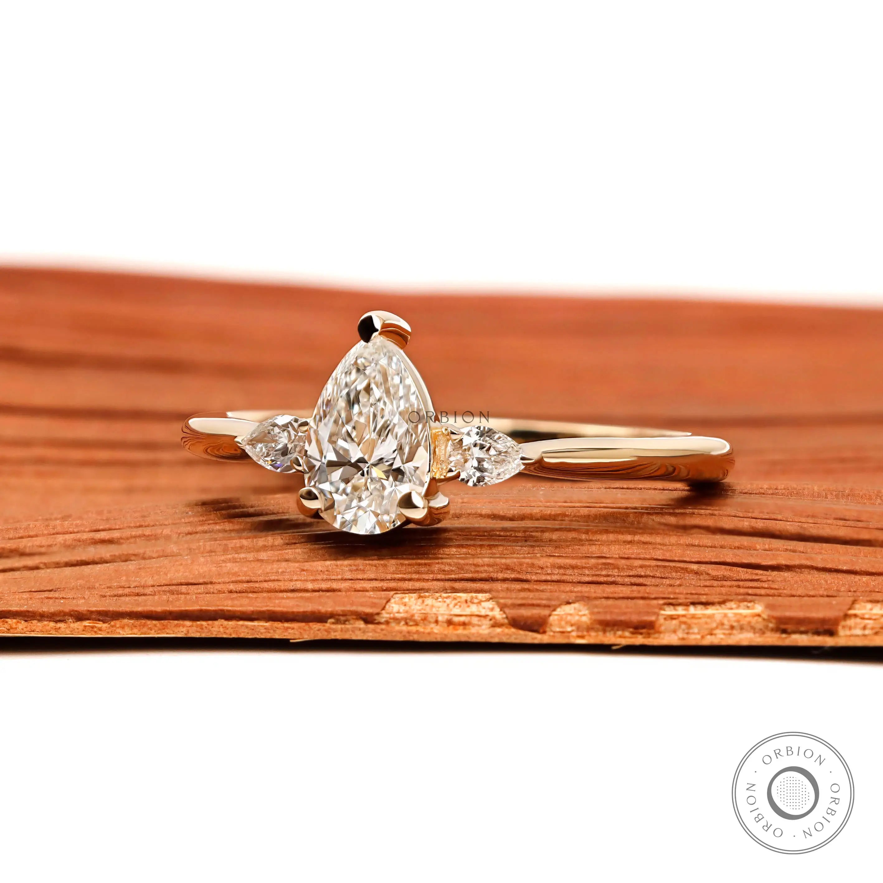 Side view of pear cut lab diamond engagement ring in yellow gold