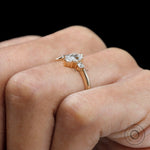 Dainty marquise center stone engagement ring with round side stones yellow gold