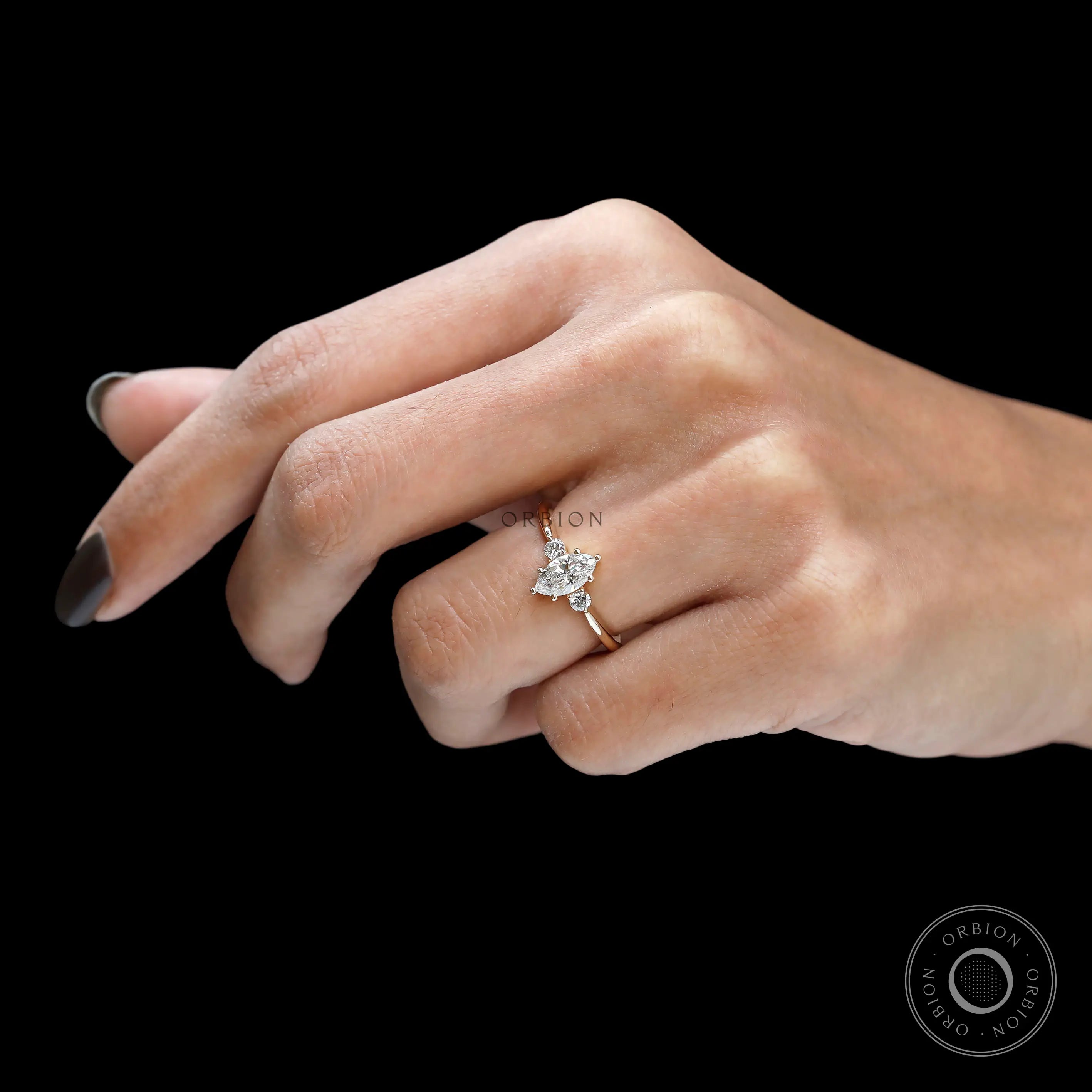 Hand worn marquise and round diamond three stone ring in yellow gold