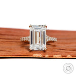 4.5 ct emerald cut moissanite engagement ring with split shank and pave stones in 10k yellow gold