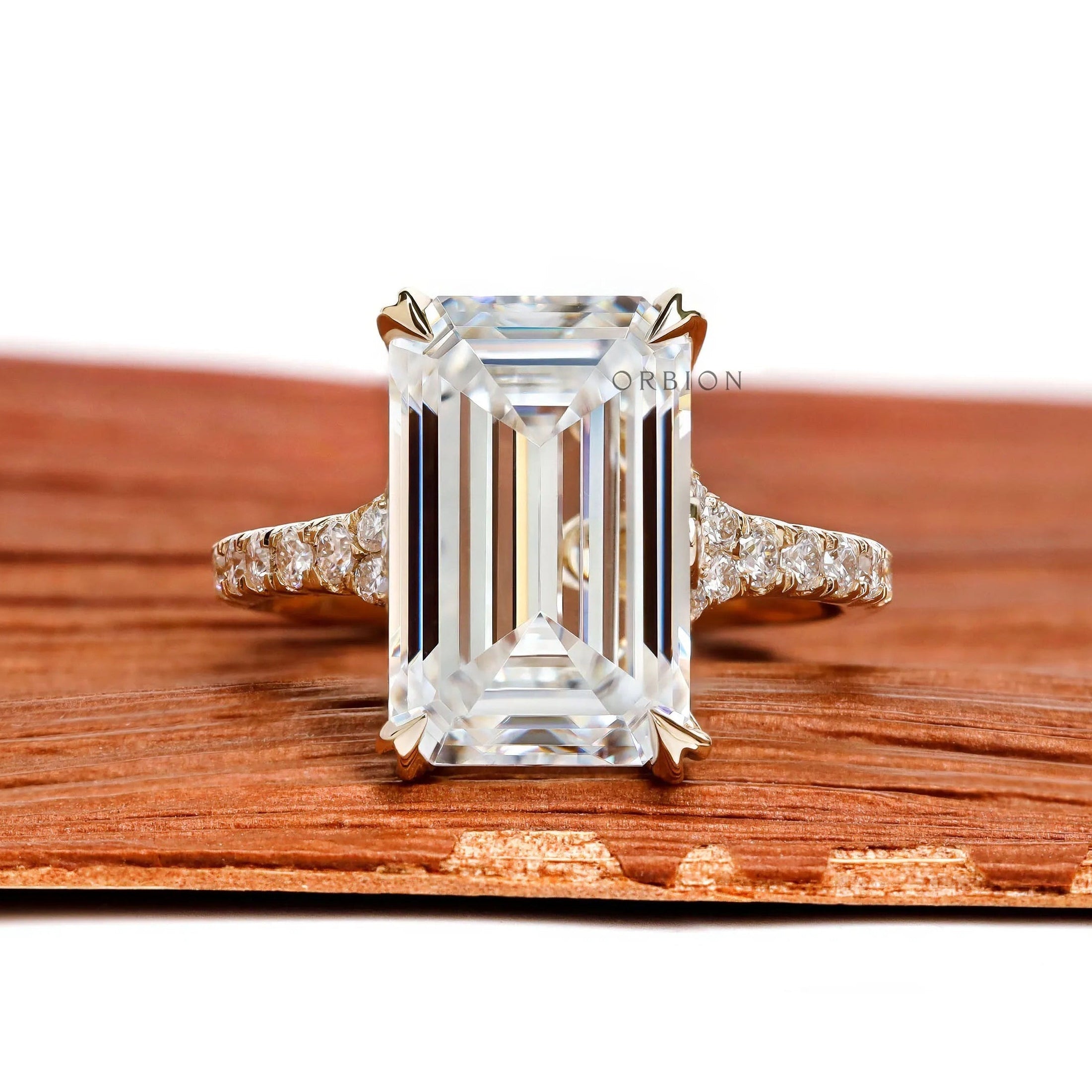 4.5 ct emerald cut moissanite engagement ring with split shank and pave stones in 10k yellow gold