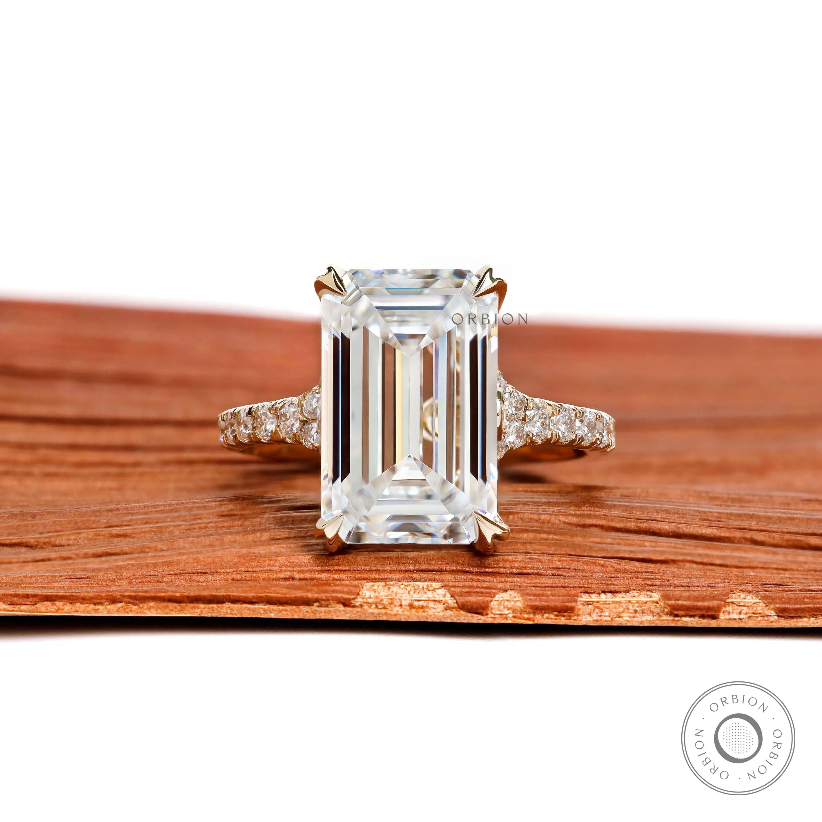 4.5 ct emerald cut moissanite engagement ring with split shank and pave stones in 10k yellow gold