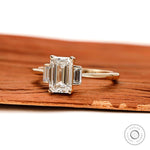 Side view of emerald cut engagement ring with baguette accents