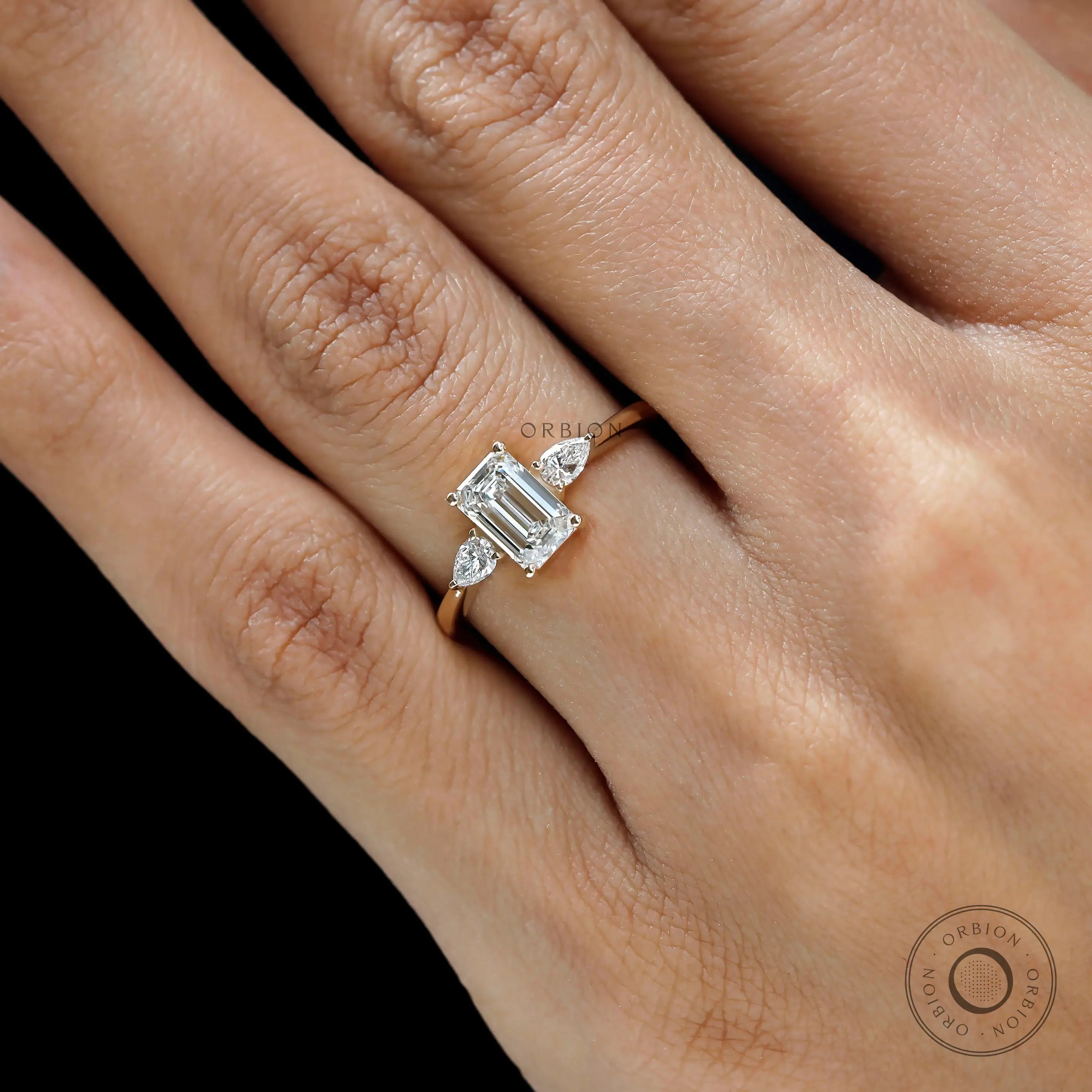 Close up of emerald cut center stone three stone ring