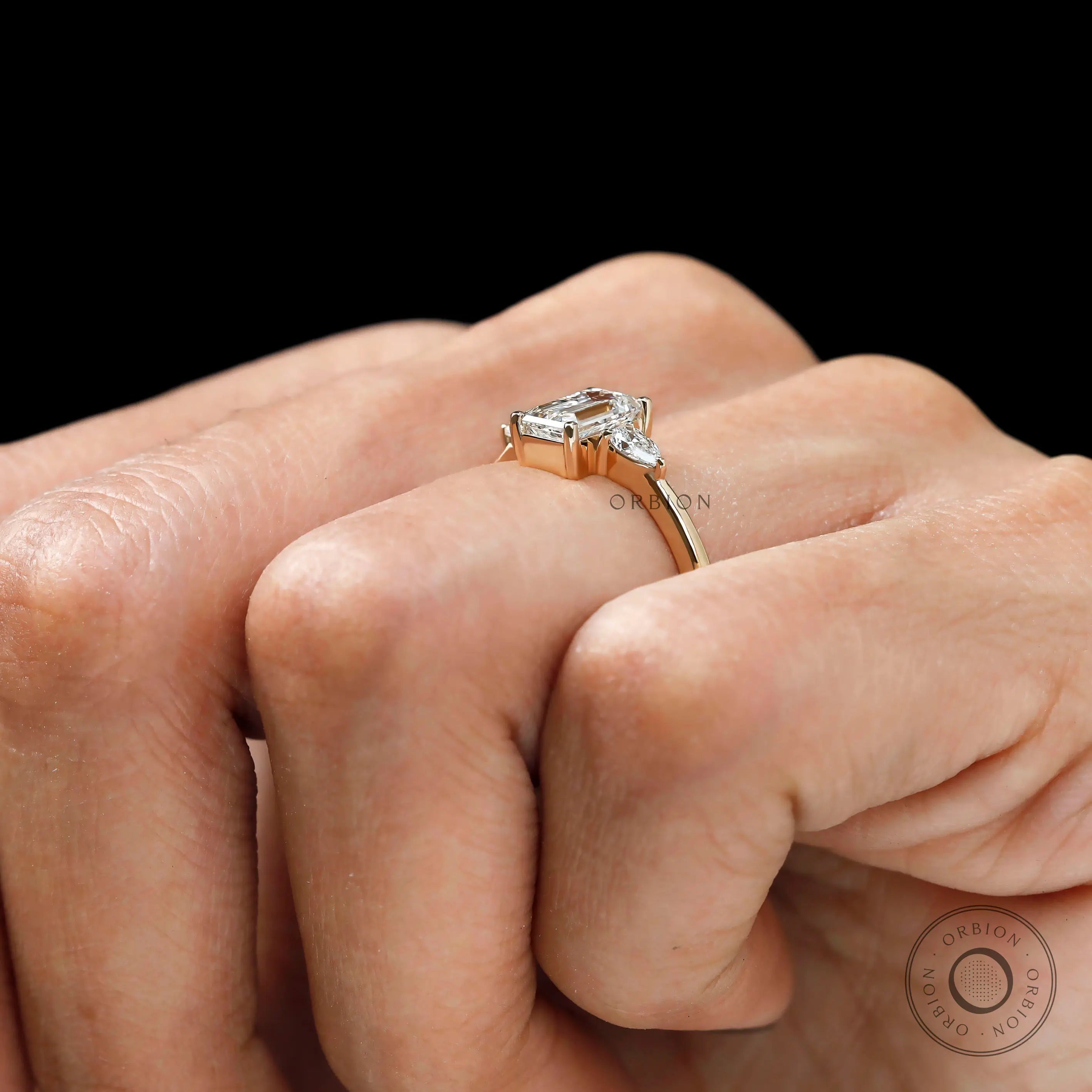Lab diamond three stone engagement ring worn on hand