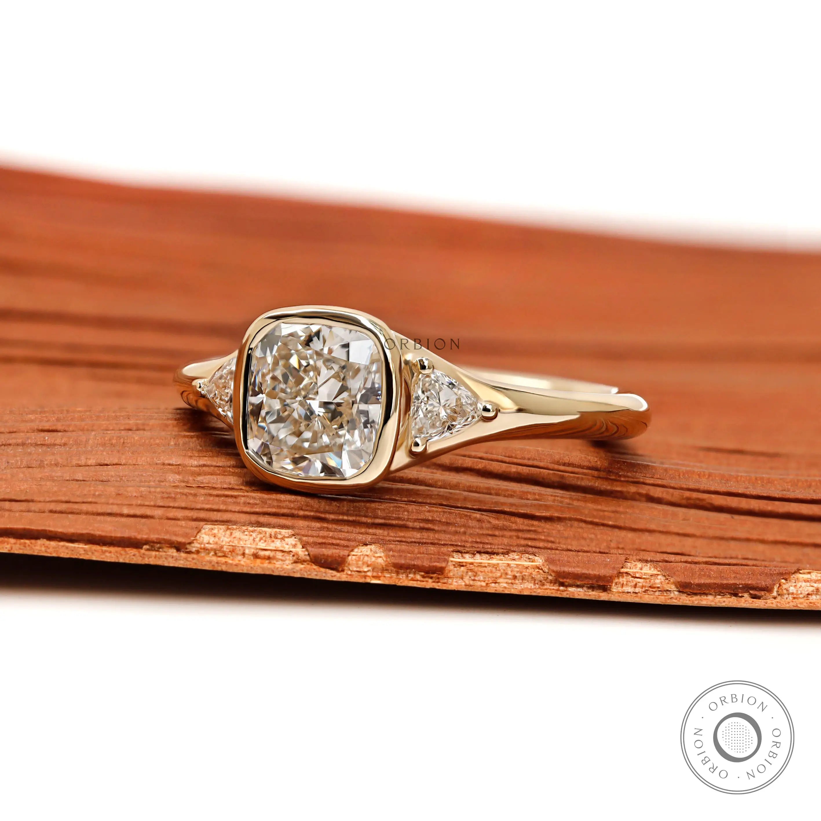 Three stone engagement ring showing bezel center and prong side stones