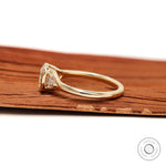 Side profile of floating cushion bezel engagement ring in 10K yellow gold