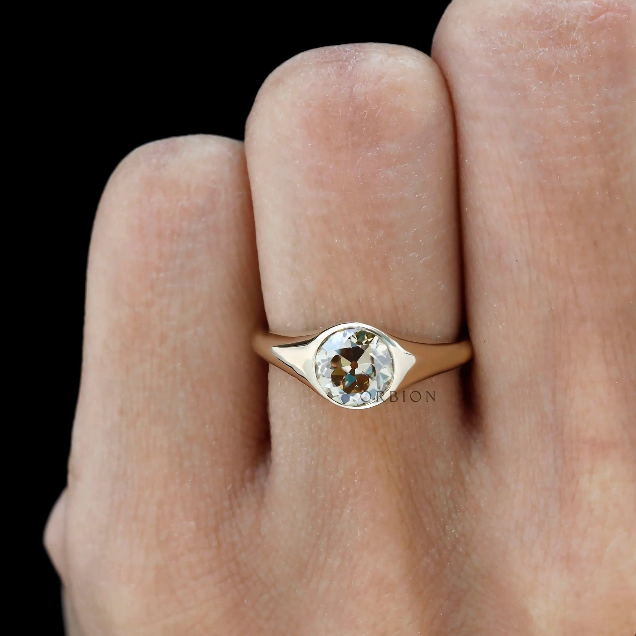 Minimalist bezel set champagne moissanite ring on finger