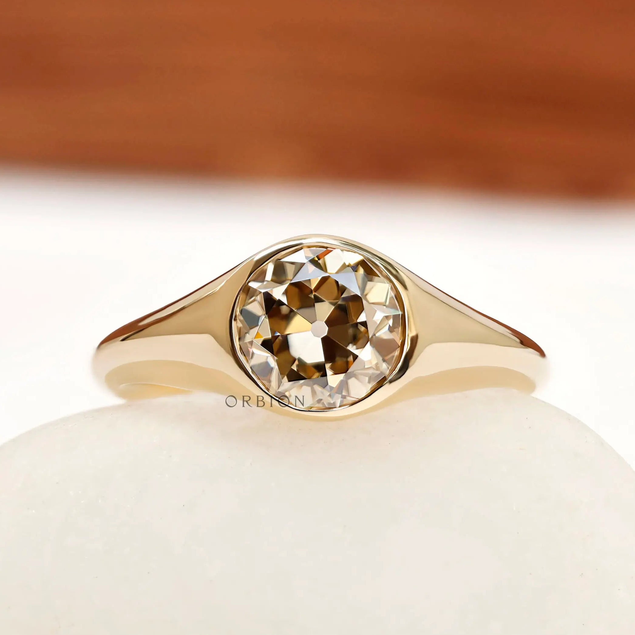 Round old european cut champagne moissanite bezel set signet ring in 14k yellow gold front view