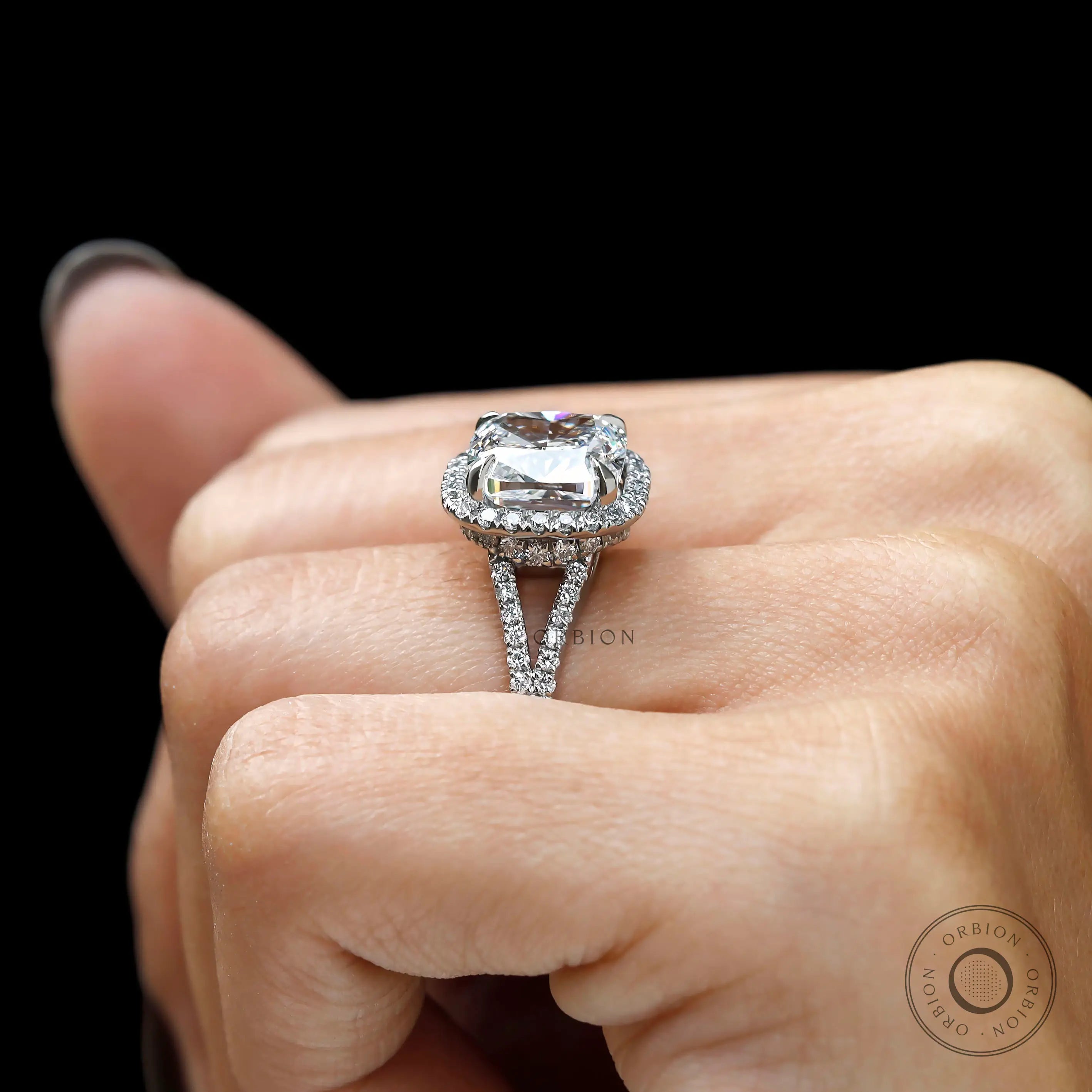 Hand shot of cushion cut halo engagement ring in Platinum 950
