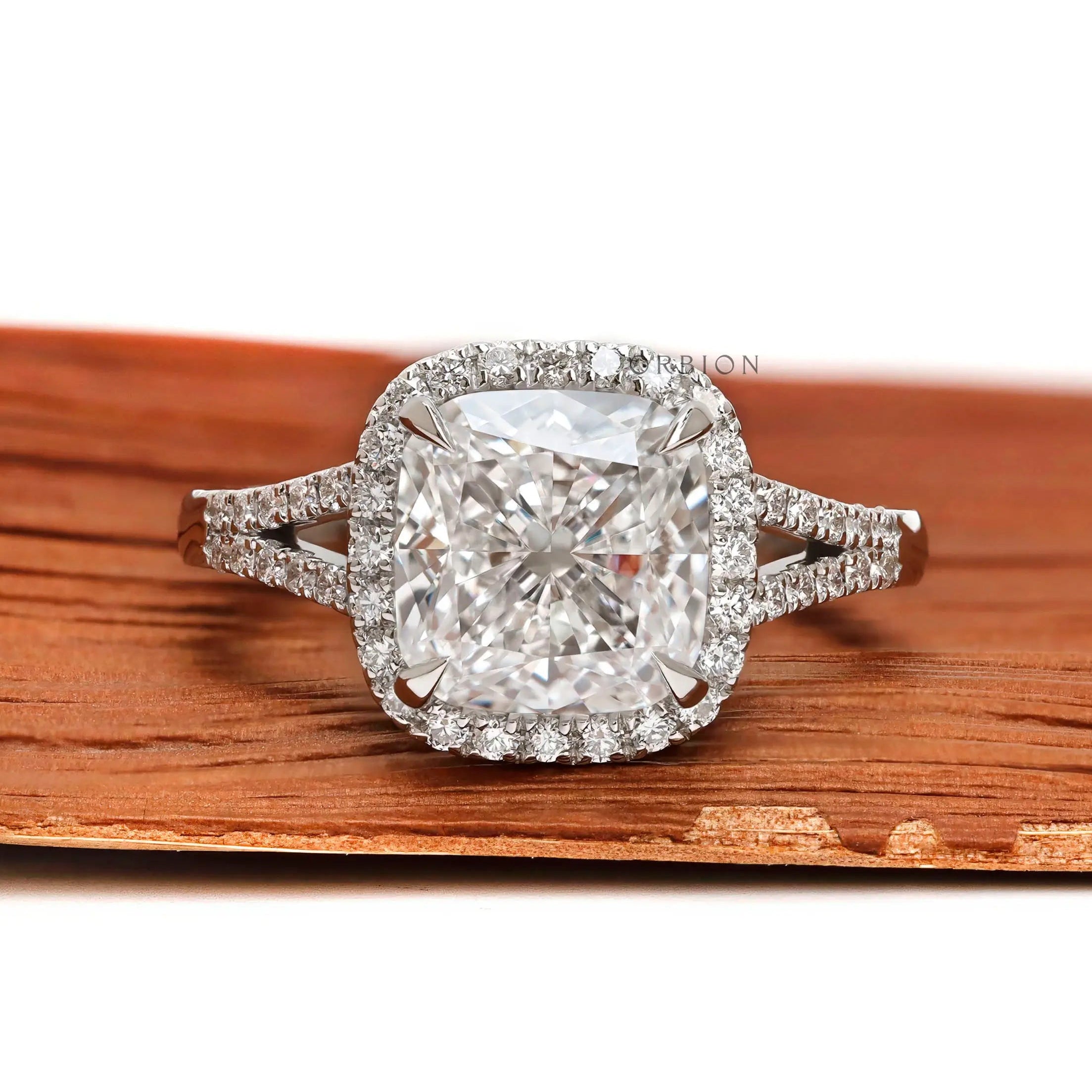 Cushion cut halo engagement ring with split shank pavé band in platinum