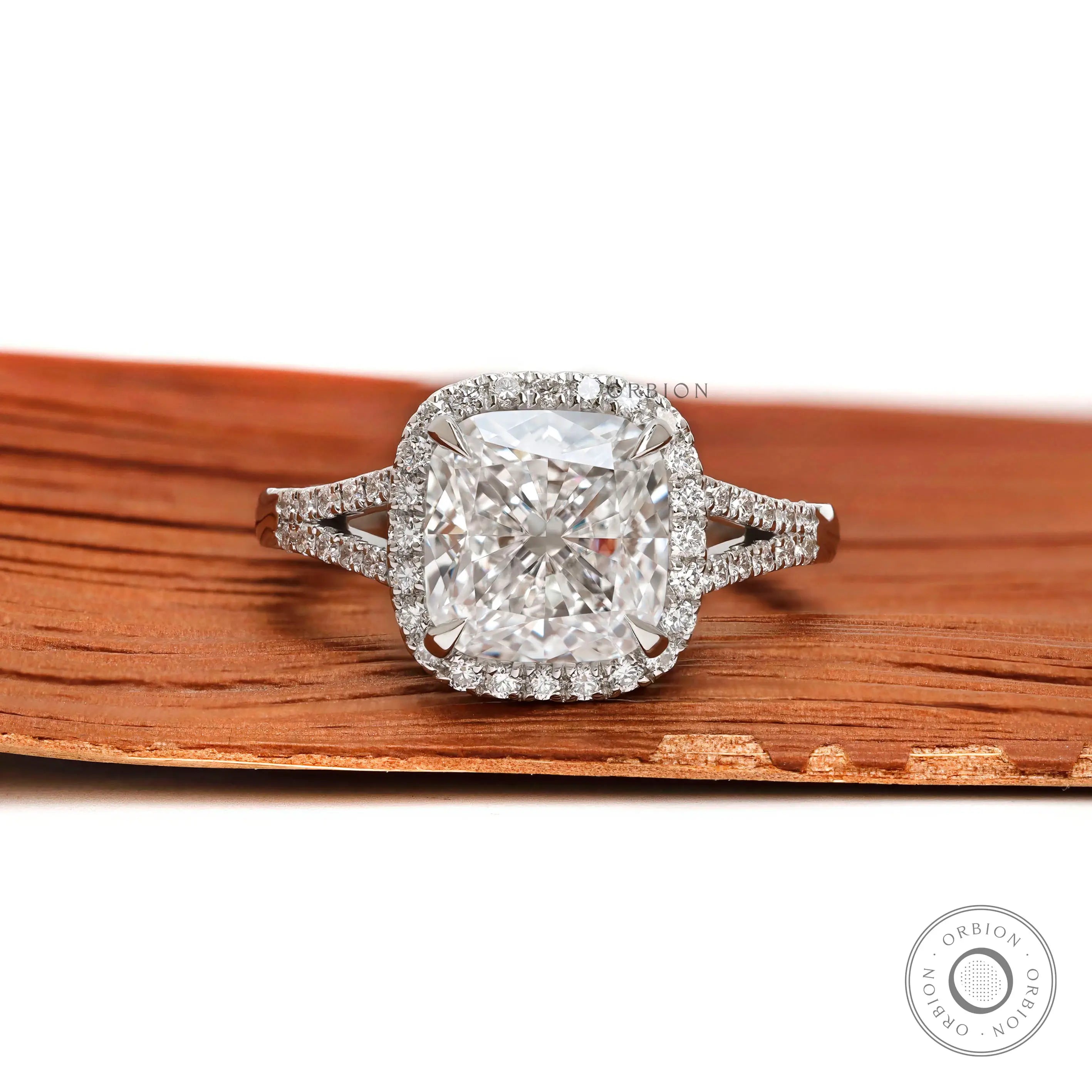 Cushion cut halo engagement ring with split shank pavé band in platinum