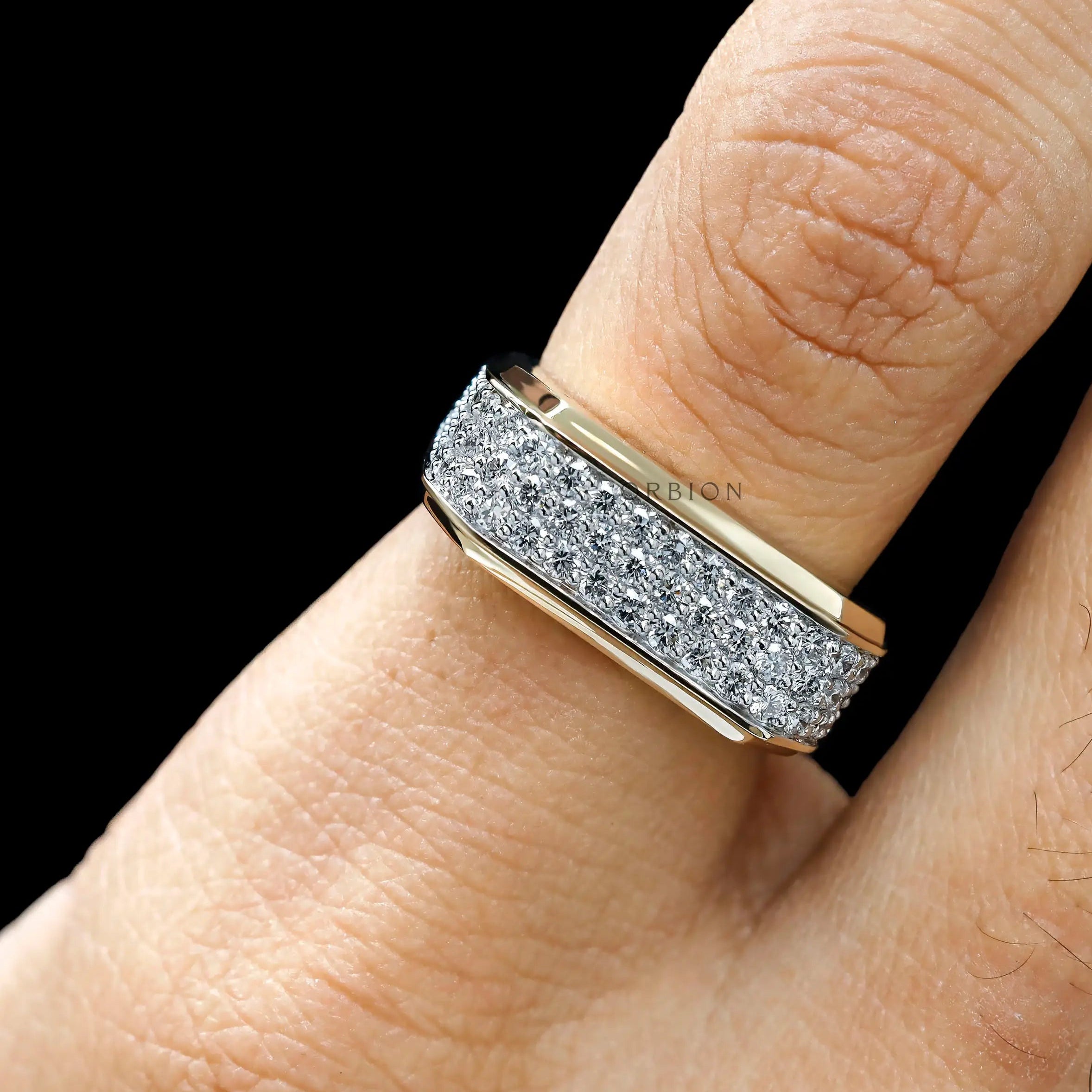 Close-up of pavé diamond setting on men’s yellow gold ring
