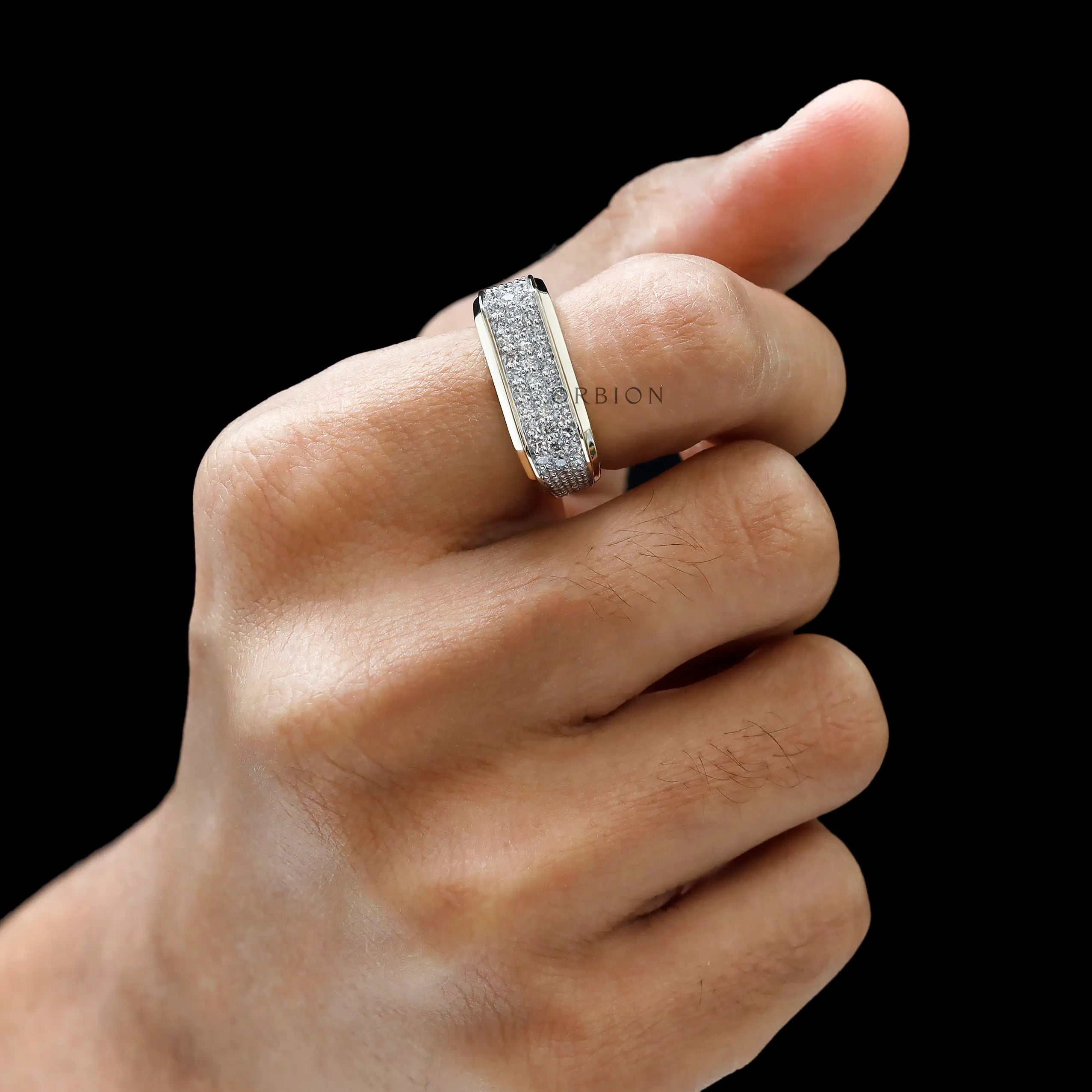 pavé diamond setting on men’s yellow gold ring on finger